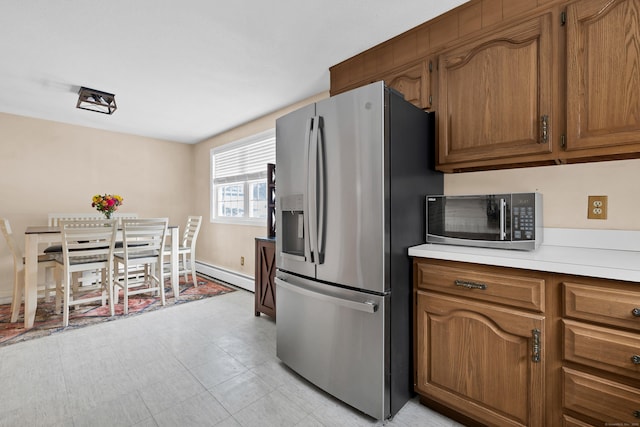 kitchen featuring a baseboard heating unit, stainless steel appliances, light countertops, and brown cabinets