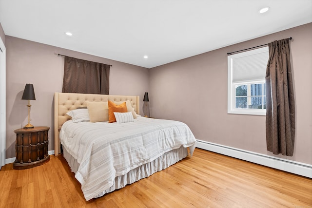 bedroom with recessed lighting, baseboards, baseboard heating, and wood finished floors