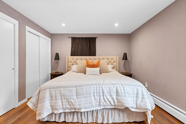 bedroom featuring baseboard heating, light wood-style flooring, and recessed lighting