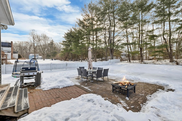 yard covered in snow with an outdoor fire pit and fence