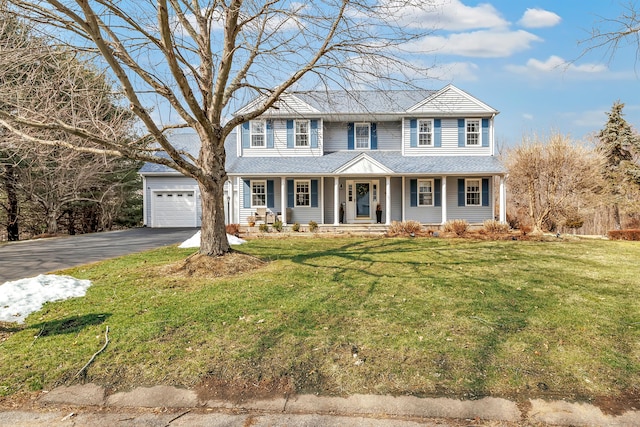 colonial-style house with driveway, a front lawn, a porch, and an attached garage