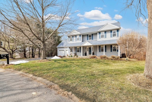 colonial inspired home with a garage, driveway, a shingled roof, a porch, and a front lawn