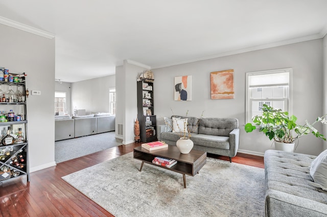 living room with baseboards, hardwood / wood-style flooring, and crown molding