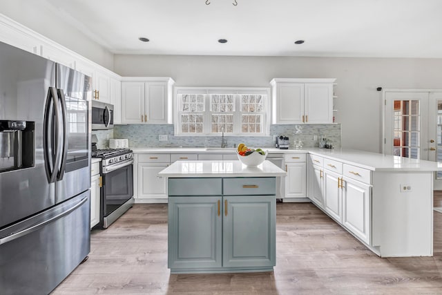 kitchen with stainless steel appliances, french doors, a peninsula, and white cabinetry