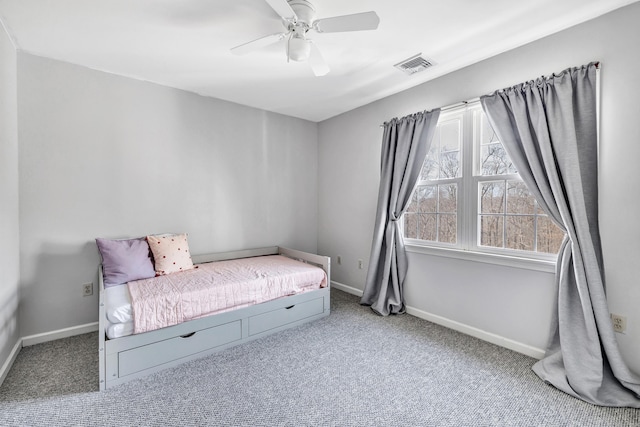 carpeted bedroom with a ceiling fan, visible vents, and baseboards