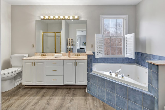 full bath featuring wood finished floors, a jetted tub, a sink, and a shower stall