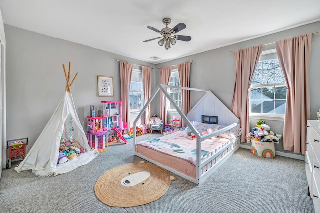 bedroom featuring carpet, multiple windows, visible vents, and ceiling fan