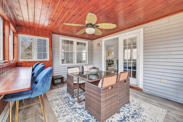 exterior space featuring a healthy amount of sunlight, wooden ceiling, a sunroom, and wood finished floors