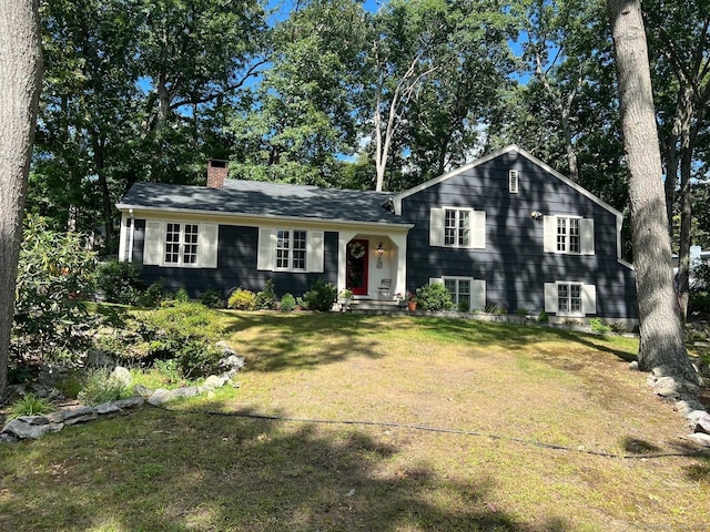 tri-level home with a chimney and a front yard