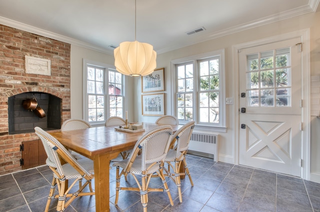 dining area with radiator heating unit, a fireplace, visible vents, and crown molding