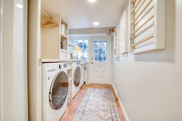 washroom with laundry area, washing machine and dryer, and baseboards