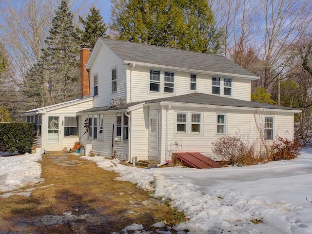 view of front of property featuring a sunroom and a chimney