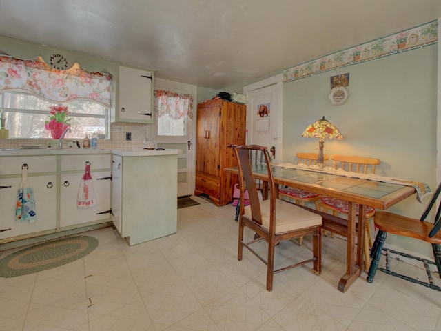 kitchen featuring light floors, white cabinetry, light countertops, and backsplash