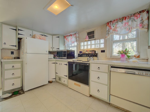 kitchen with light countertops, white appliances, backsplash, and white cabinetry