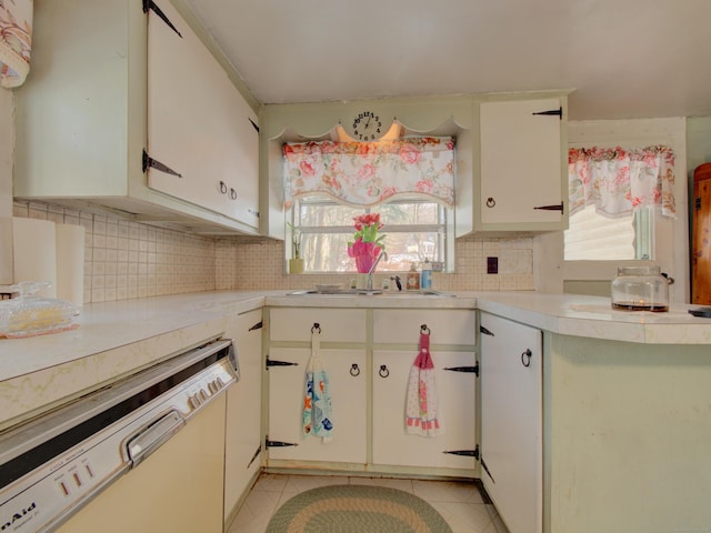 kitchen with white cabinets, light tile patterned floors, white dishwasher, and light countertops