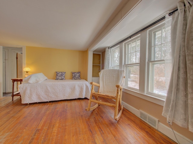 bedroom featuring baseboards, visible vents, and hardwood / wood-style floors