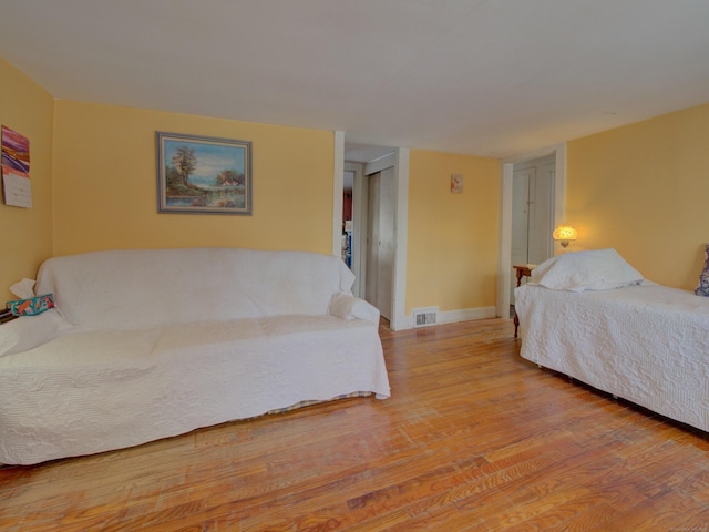 bedroom with light wood-style floors, baseboards, and visible vents