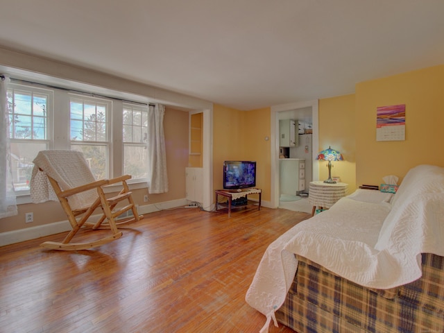 bedroom featuring light wood-type flooring, multiple windows, and baseboards