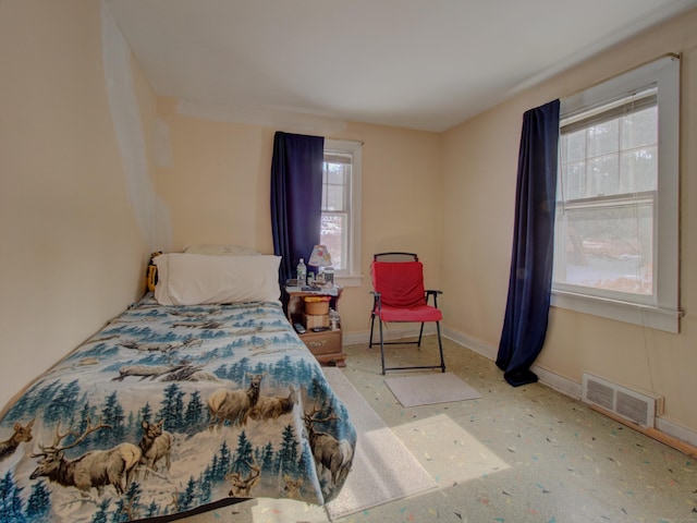 bedroom featuring baseboards and visible vents