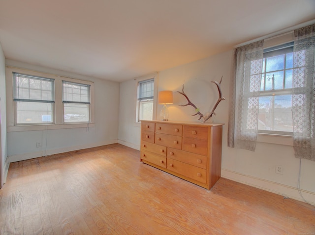 spare room featuring light wood-style flooring and baseboards