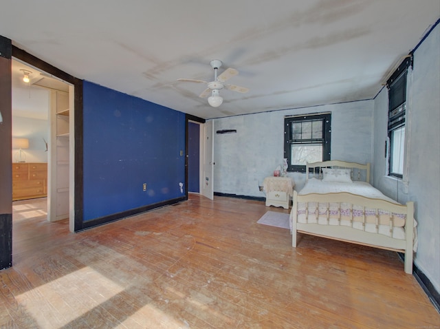 unfurnished bedroom with ceiling fan, hardwood / wood-style flooring, and attic access