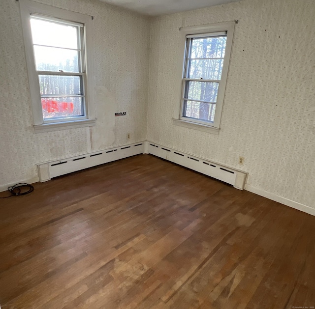 280 Merrow Rd, Tolland, CT 06084 - spare room with dark wood-type flooring, a baseboard heating unit, baseboards, and wallpapered walls