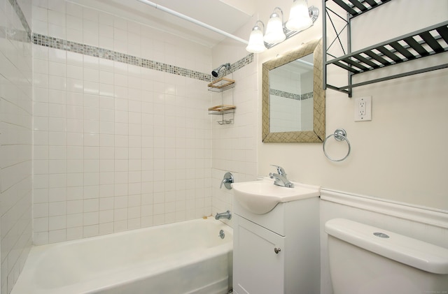 bathroom featuring toilet, a wainscoted wall, washtub / shower combination, and vanity