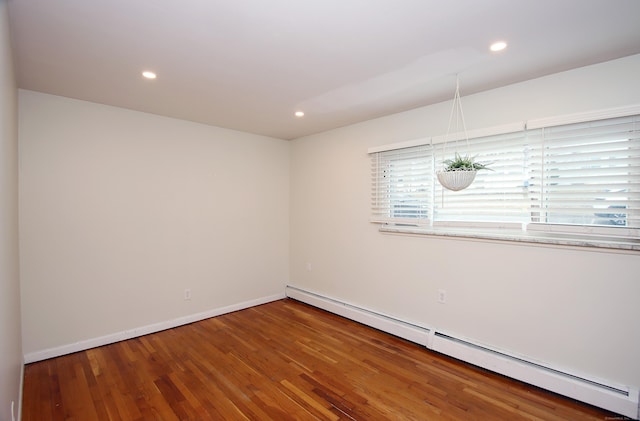 unfurnished room featuring a baseboard radiator, baseboards, recessed lighting, and wood finished floors