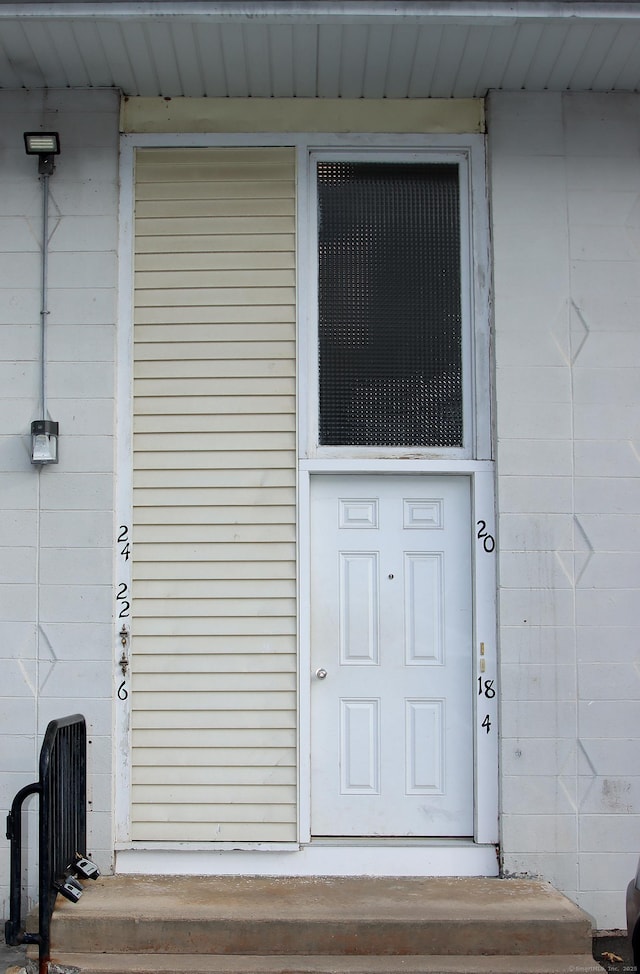 view of exterior entry featuring concrete block siding