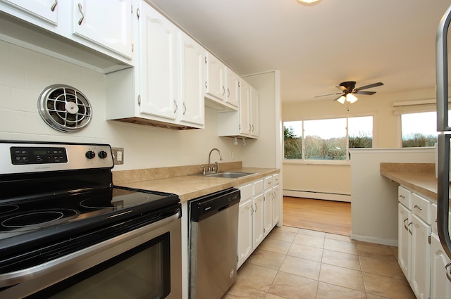 kitchen featuring appliances with stainless steel finishes, white cabinets, light countertops, and a sink