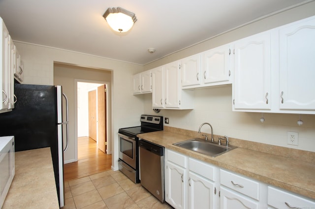 kitchen featuring stainless steel appliances, a sink, and white cabinetry