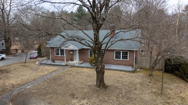 ranch-style house featuring brick siding, a shingled roof, and fence