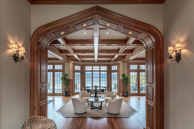 living area with coffered ceiling, wood finished floors, and beam ceiling