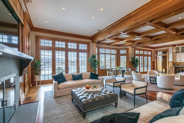 living area featuring light wood finished floors, french doors, beamed ceiling, and coffered ceiling