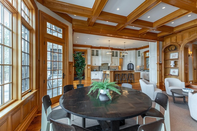 dining area with arched walkways, coffered ceiling, beam ceiling, and ornamental molding