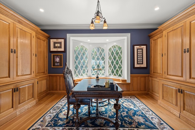 office with a wainscoted wall, ornamental molding, and light wood finished floors