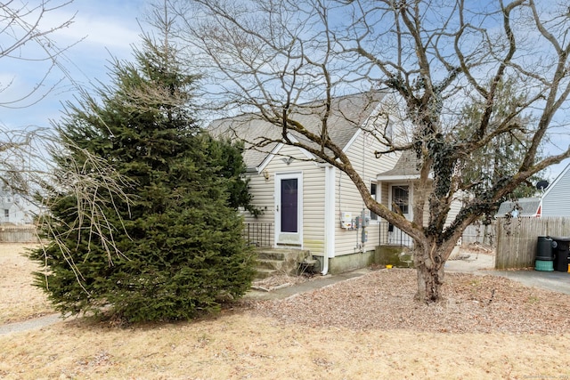 obstructed view of property featuring roof with shingles and fence