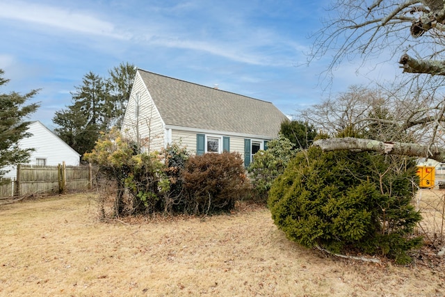 view of property exterior featuring fence and roof with shingles