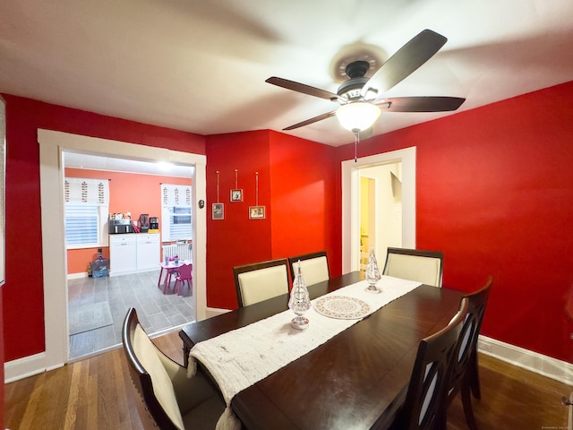 dining room with a ceiling fan, baseboards, and wood finished floors