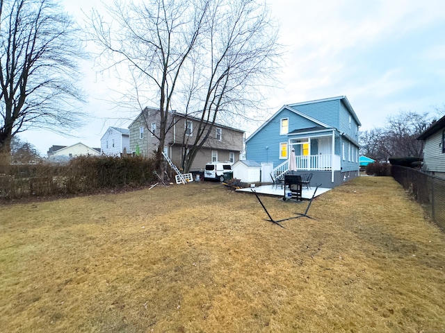 back of property with a patio area, fence, and a lawn