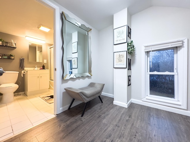 full bathroom with vaulted ceiling, wood finished floors, toilet, and baseboards