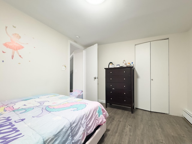 bedroom featuring a baseboard radiator, a closet, and wood finished floors