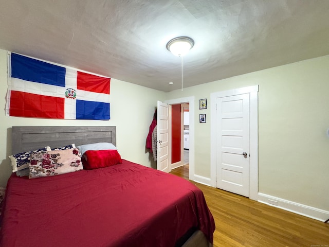 bedroom with wood finished floors and baseboards