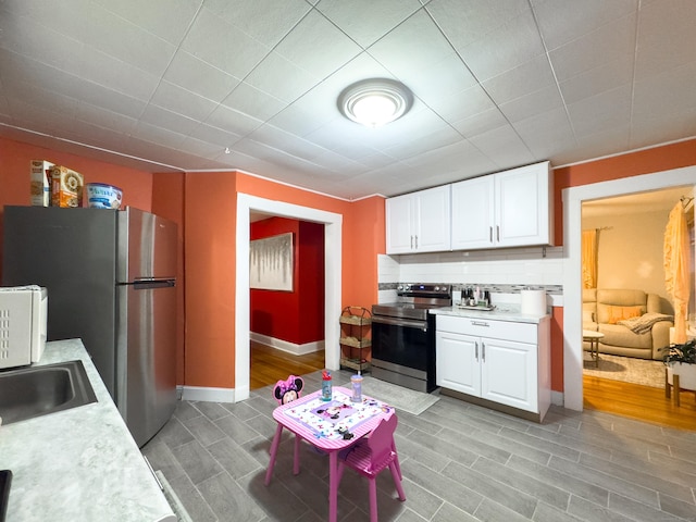 kitchen featuring appliances with stainless steel finishes, light countertops, and white cabinetry