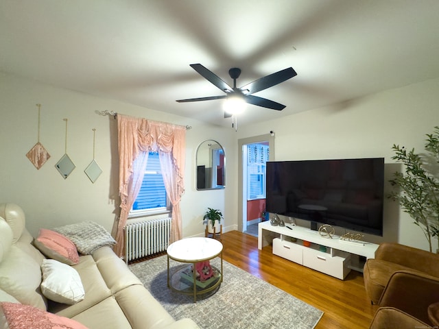 living room with ceiling fan, radiator heating unit, wood finished floors, and baseboards