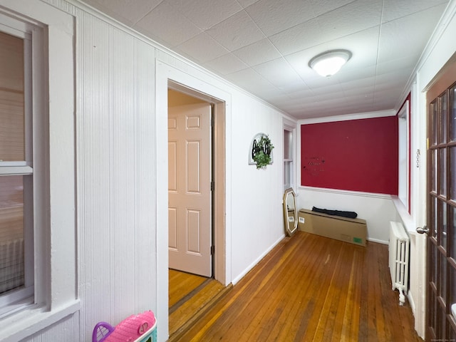 corridor featuring wood-type flooring and radiator heating unit