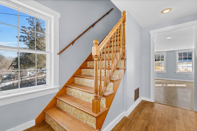 staircase with baseboards, visible vents, wood finished floors, and recessed lighting