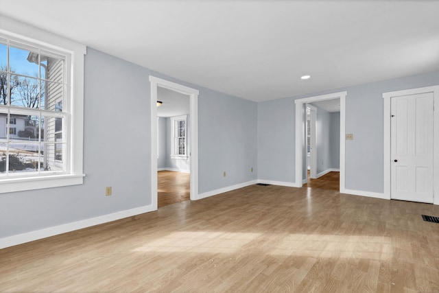 interior space with visible vents, light wood-type flooring, a wealth of natural light, and baseboards