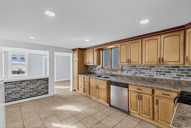 kitchen with dark countertops, a sink, tasteful backsplash, and dishwasher