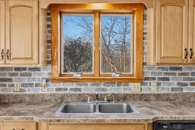 kitchen featuring dishwashing machine, a sink, and light brown cabinetry